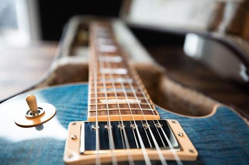 Close up of a blue guitar in an open case.